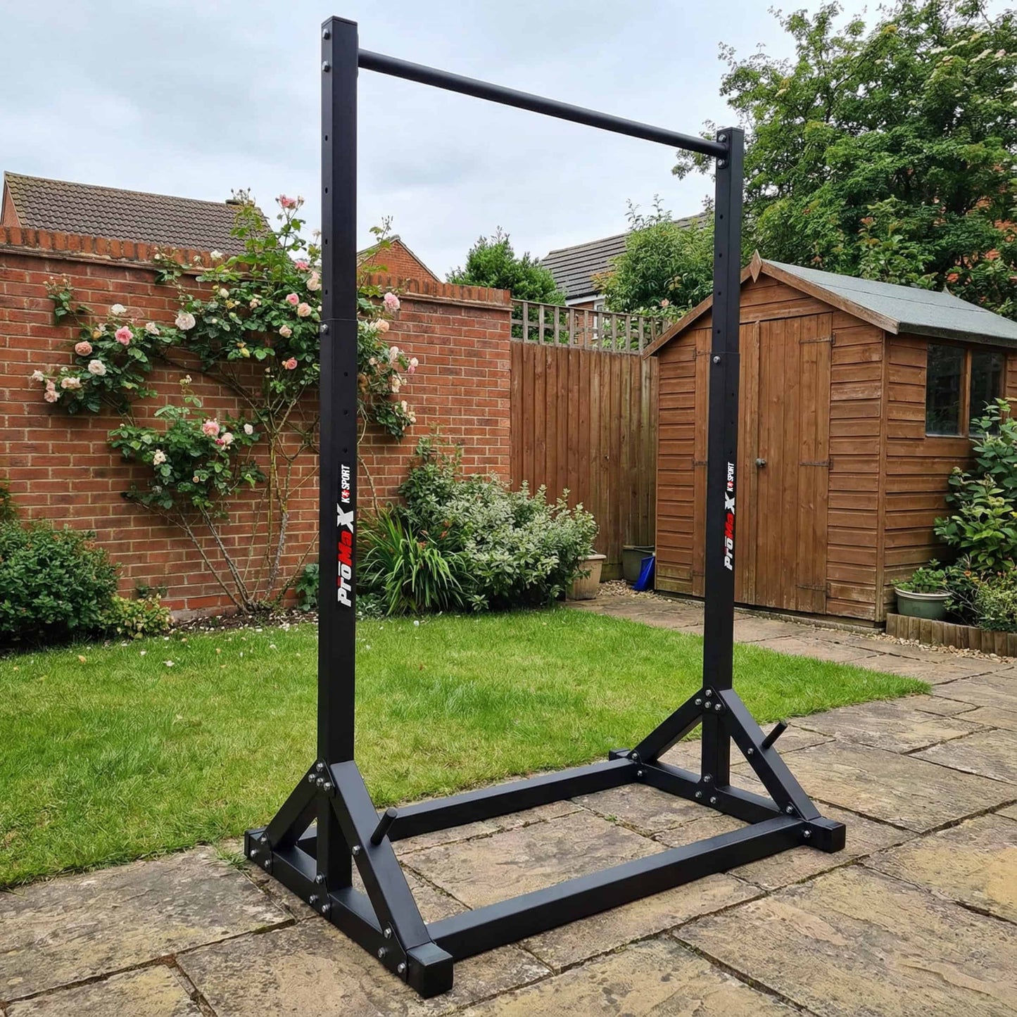 Outdoor setup of freestanding pull-up bar in garden, portable calisthenics and bodyweight training equipment