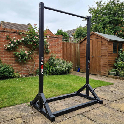 Outdoor setup of freestanding pull-up bar in garden, portable calisthenics and bodyweight training equipment
